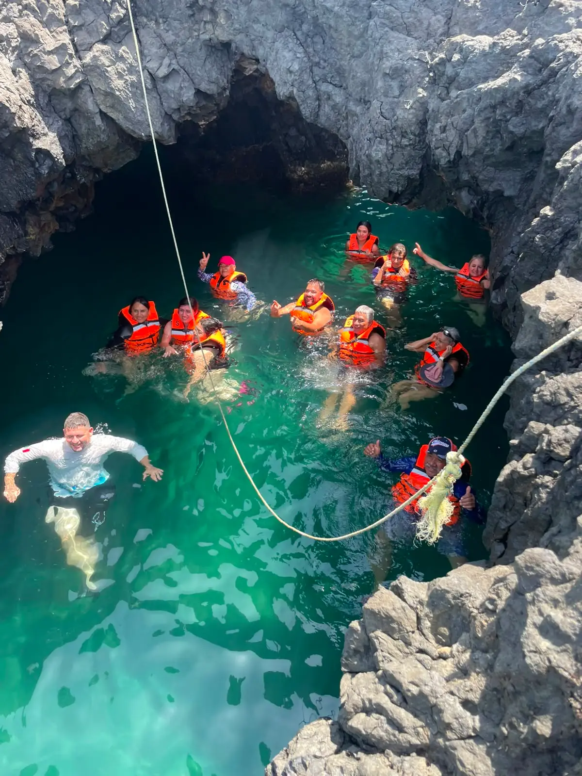 Guía de BoteTur ayudando a viajeras entre las rocas de la costa